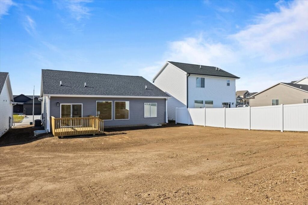 A house surrounded by a fence and yard, highlighting New Gladiator Homes available at 304 S Valley View Dr, Norwalk, IA.