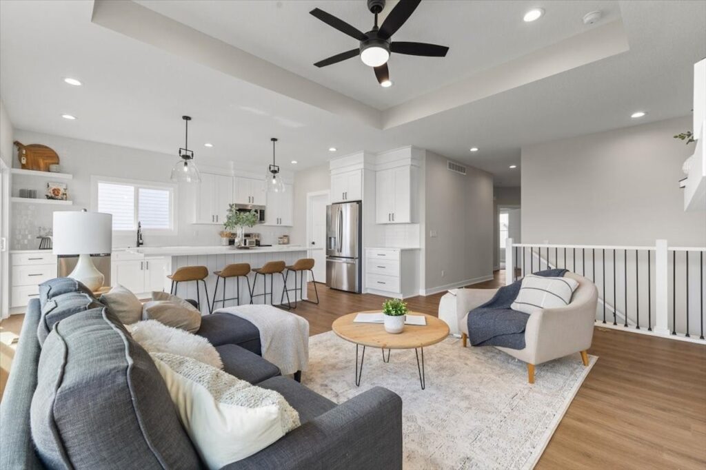 Spacious kitchen and living room featuring hardwood floors in a new Gladiator home for sale at 304 S Valley View Dr, Norwalk, IA.