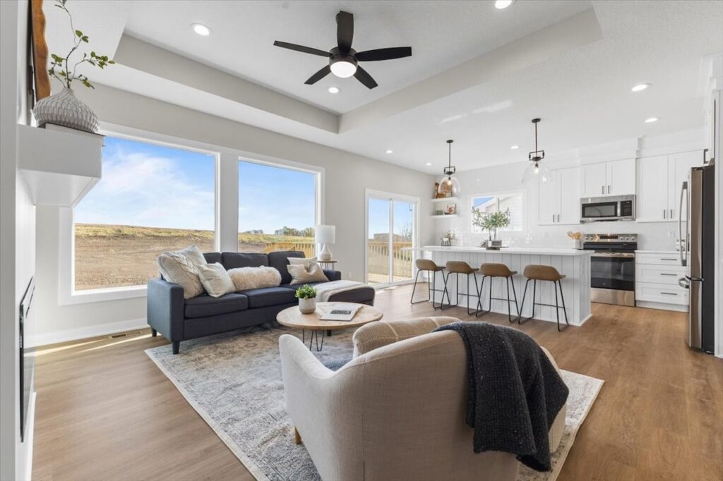 Kitchen and living room with hardwood floors in a new Gladiator home for sale at 304 S Valley View Dr, Norwalk, IA.