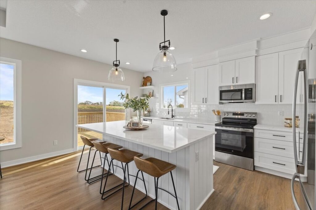 Elegant kitchen with white cabinets and a marble island, highlighting new Gladiator Homes for sale at 304 S Valley View Dr.