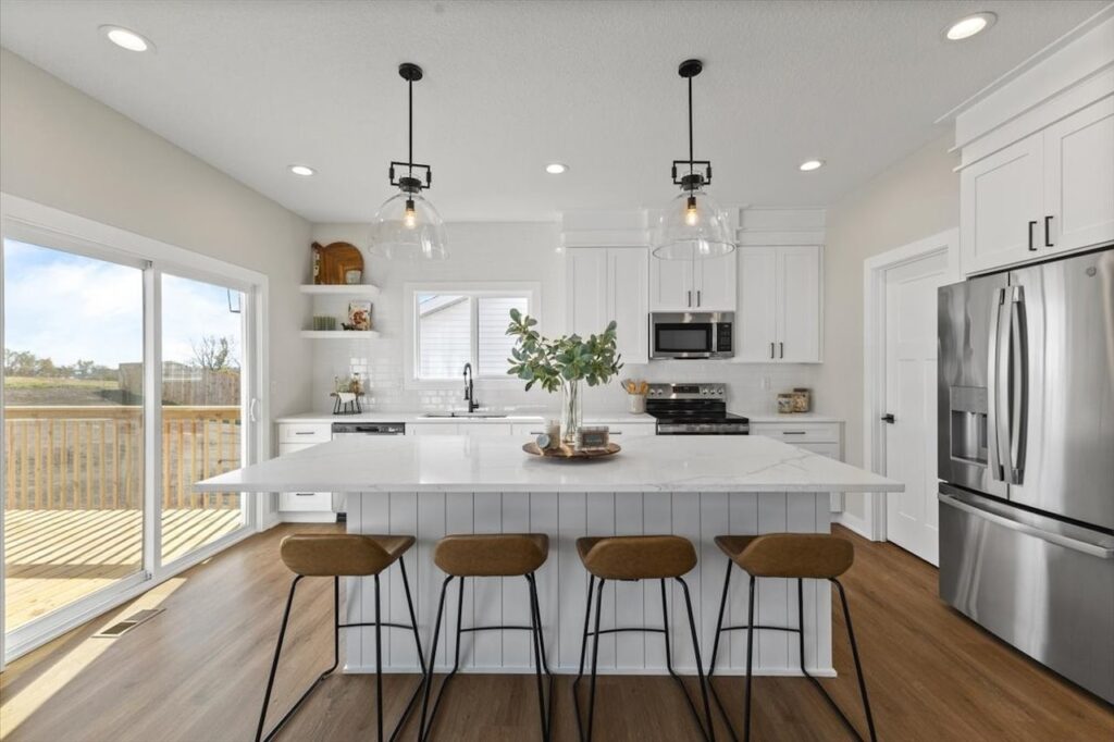 Elegant kitchen with white cabinets and a marble island, highlighting new Gladiator Homes for sale at 304 S Valley View Dr.