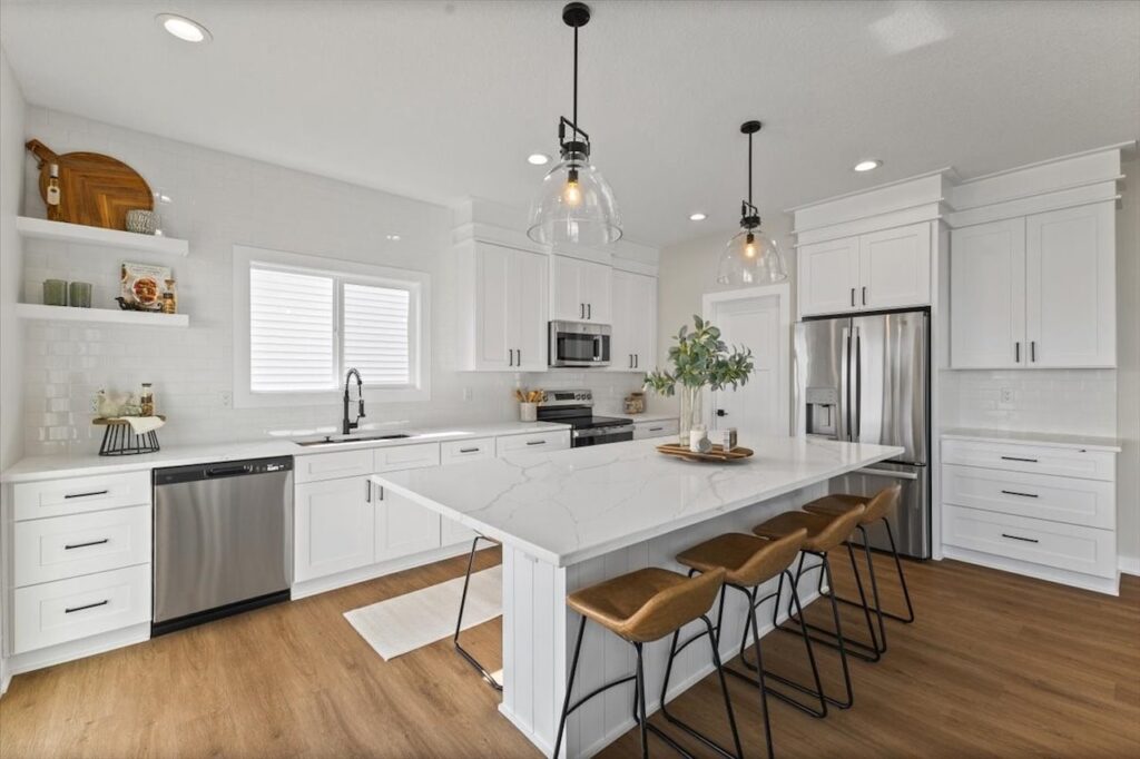 Elegant kitchen with white cabinets and a marble island, highlighting new Gladiator Homes for sale at 304 S Valley View Dr.