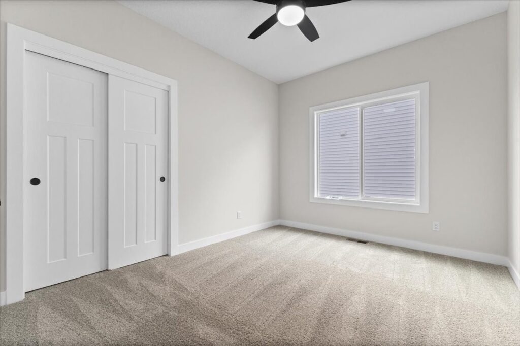 Bright, empty room with a ceiling fan and window, part of new Gladiator homes available at 304 S Valley View Dr, Norwalk.
