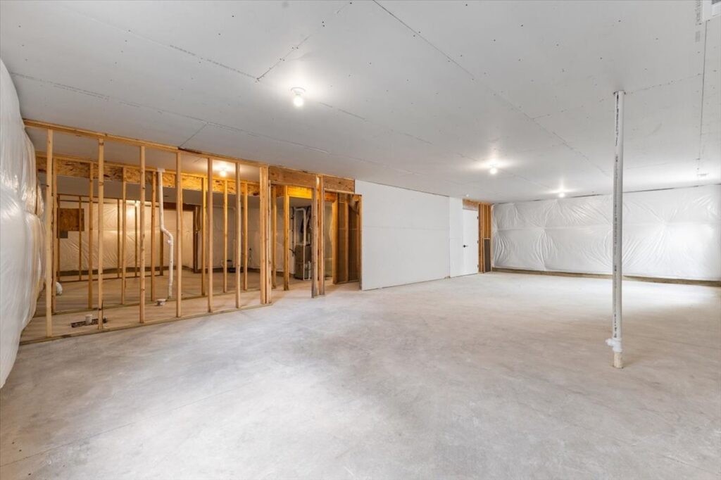 Vacant room with construction gear and a wall, highlighting new Gladiator Homes available at 304 S Valley View Dr, Norwalk, IA.