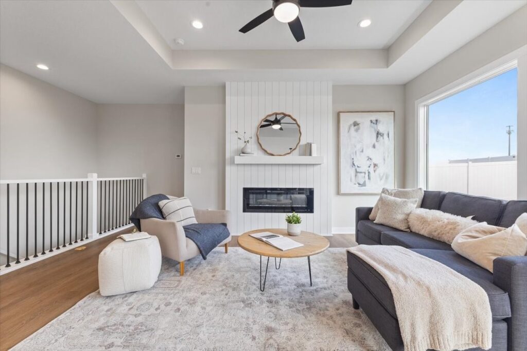 Inviting living room with a fireplace, comfortable couches, and a ceiling fan, highlighting new homes at 304 S Valley View Dr.