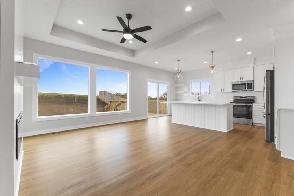 Empty room featuring a ceiling fan and a window, showcasing new Gladiator homes for sale in Norwalk, IA.