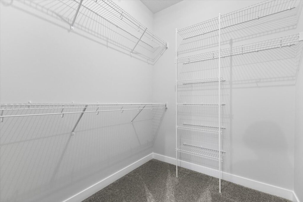 White pantry with shelves and a door, featured in new Gladiator homes for sale at 304 S Valley View Dr, Norwalk, IA.