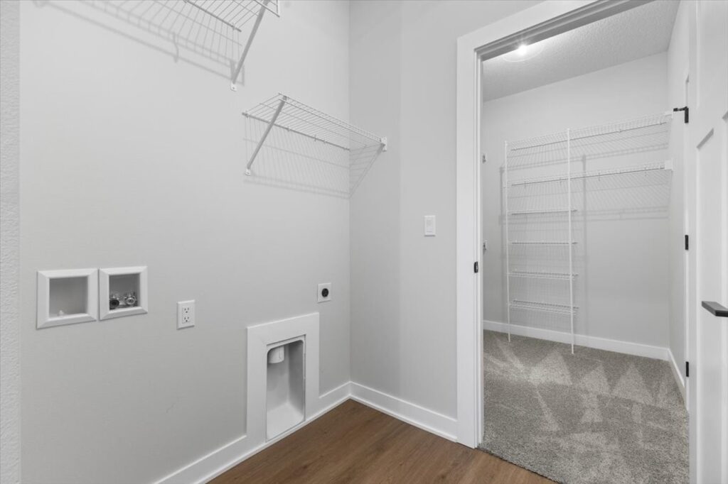 White pantry with shelves and a door, featured in new Gladiator homes for sale at 304 S Valley View Dr, Norwalk, IA.