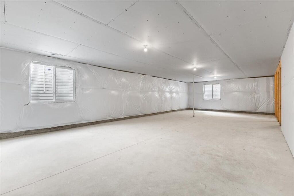 Vacant room with construction gear and a wall, highlighting new Gladiator Homes available at 308 S Valley View Dr, Norwalk, IA.