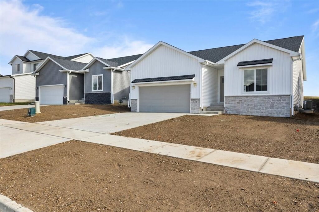 Exterior view of a new home at 308 S Valley View Dr, showcasing two garages and a long driveway.