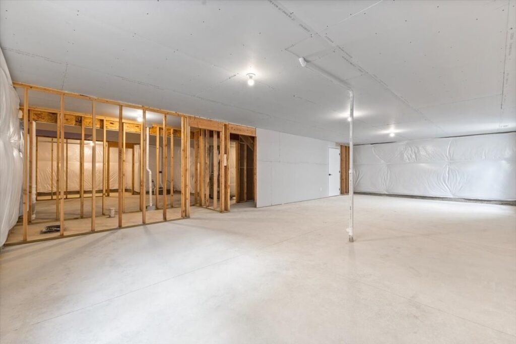 Vacant room with construction gear and a wall, highlighting new Gladiator Homes available at 308 S Valley View Dr, Norwalk, IA.