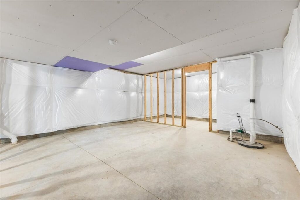 Vacant room with construction gear and a wall, highlighting new Gladiator Homes available at 308 S Valley View Dr, Norwalk, IA.