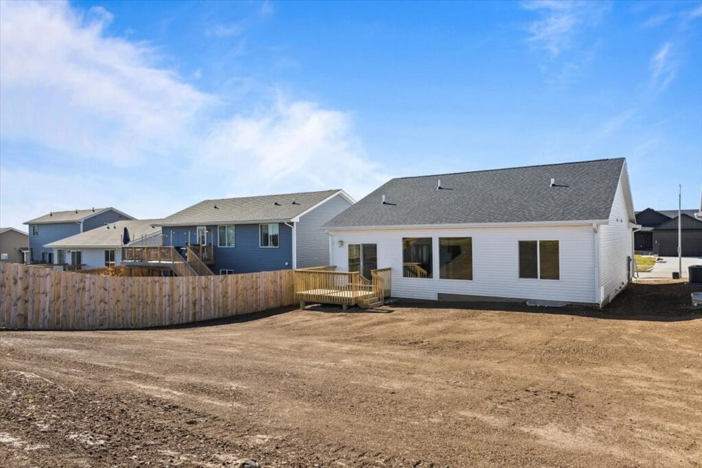 A house with a yard and driveway, showcasing new Gladiator Homes for sale at 308 S Valley View Dr, Norwalk, IA.