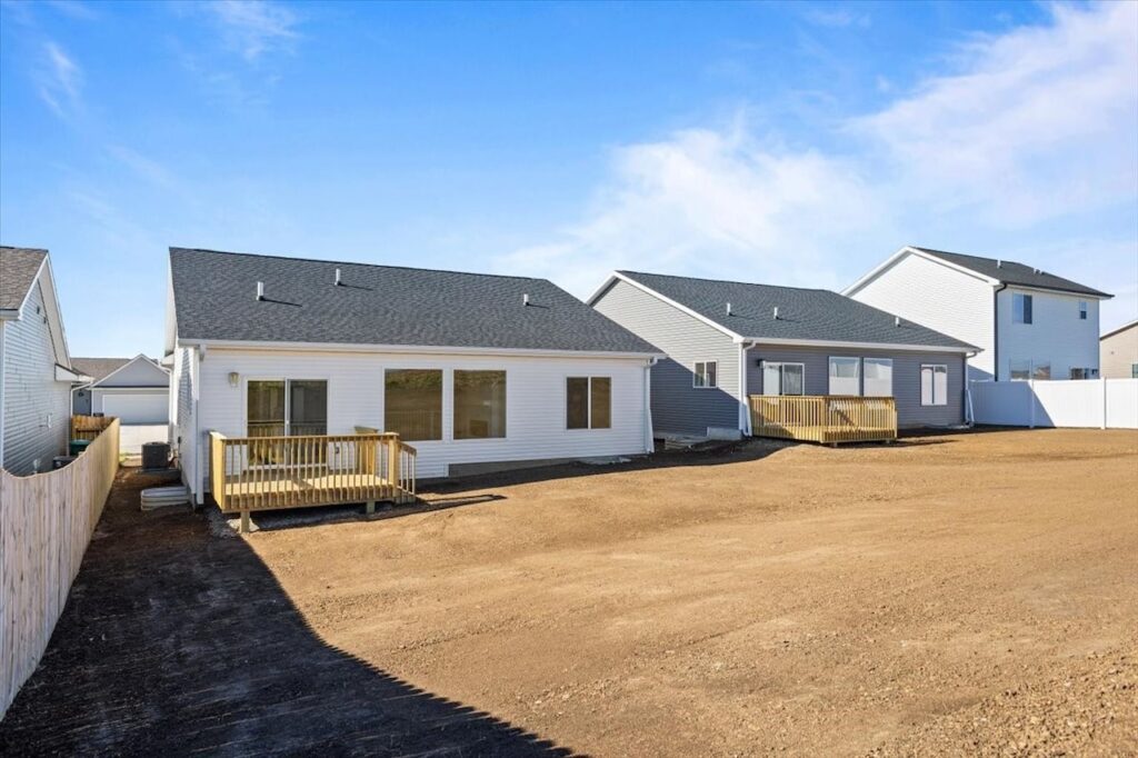 Exterior view of a house with a yard and driveway, featuring new Gladiator Homes for sale at 308 S Valley View Dr, Norwalk, IA.