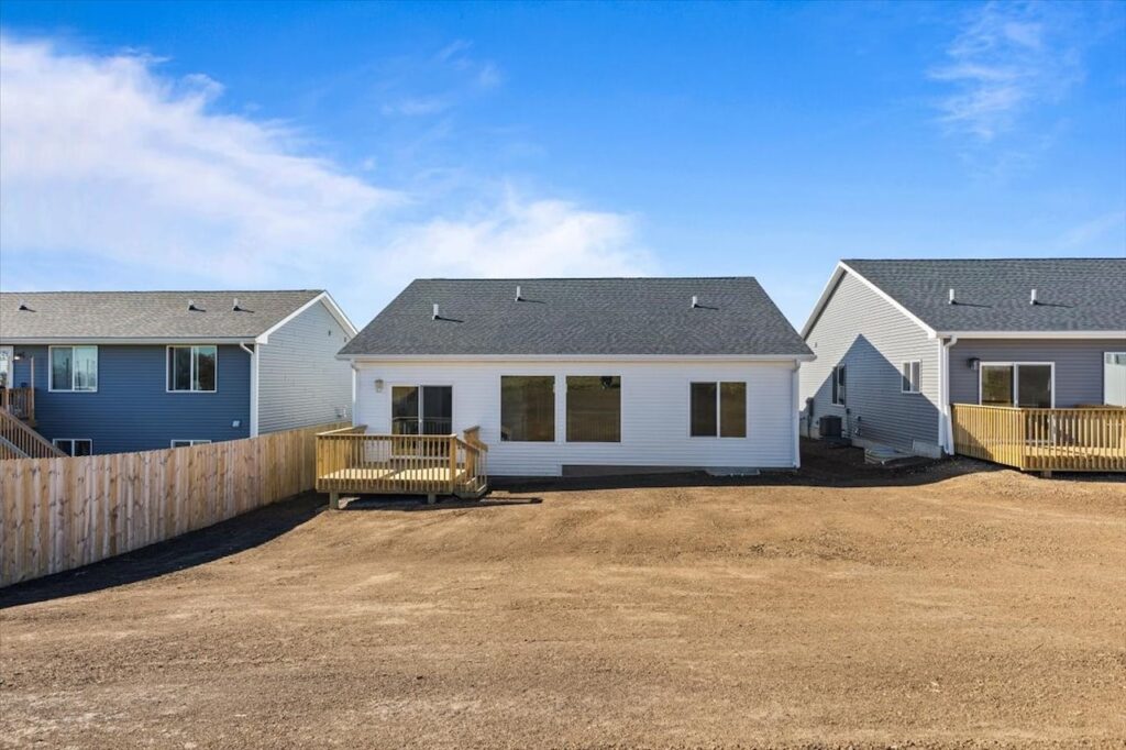 Exterior view of a house with a yard and driveway, featuring new Gladiator Homes for sale at 308 S Valley View Dr, Norwalk, IA.