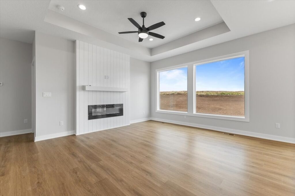 Empty room featuring a ceiling fan and a window, showcasing new Gladiator homes for sale in Norwalk, IA.