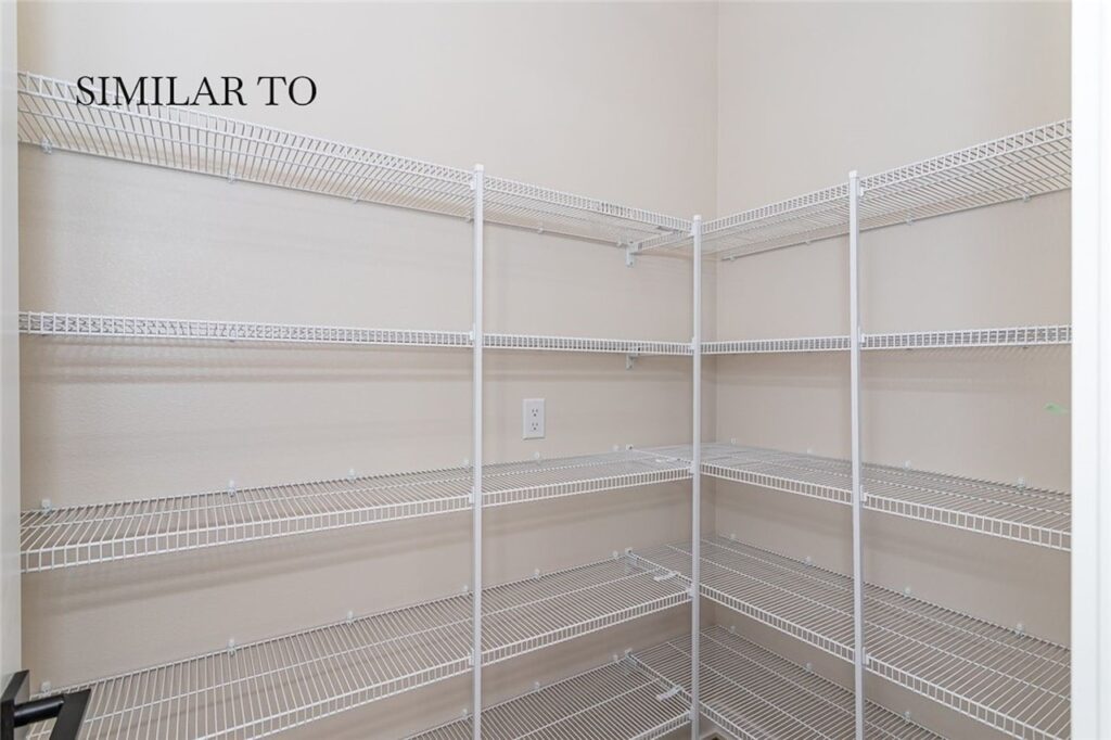 Interior view of a white pantry with shelves and a door, part of Gladiator Homes for sale at 308 S Valley View Dr, Norwalk, IA.