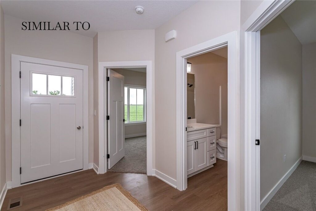 Interior hallway with a door and toilet, showcasing new Gladiator Homes available at 308 S Valley View Dr, Norwalk, IA.