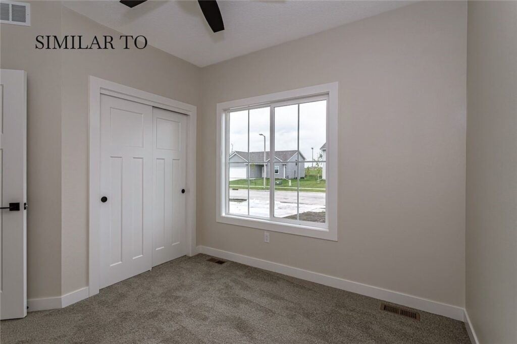 Interior view of a room featuring a ceiling fan and a window, showcasing new homes for sale by Gladiator Homes in Norwalk, IA.