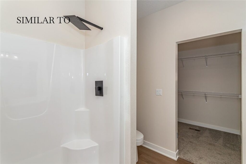 Bathroom featuring a shower and walk-in closet in a new home for sale at 308 S Valley View Dr, Norwalk, IA.