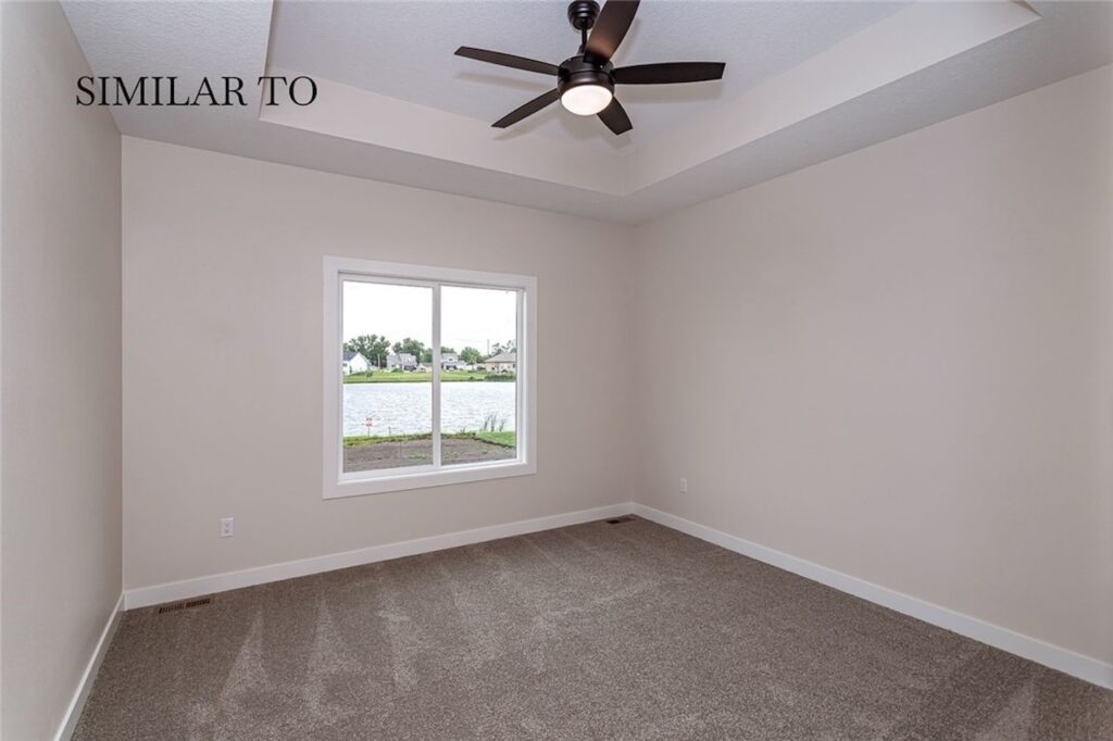 Spacious empty room with a ceiling fan and carpet, available in Gladiator Homes at 308 S Valley View Dr, Norwalk, IA
