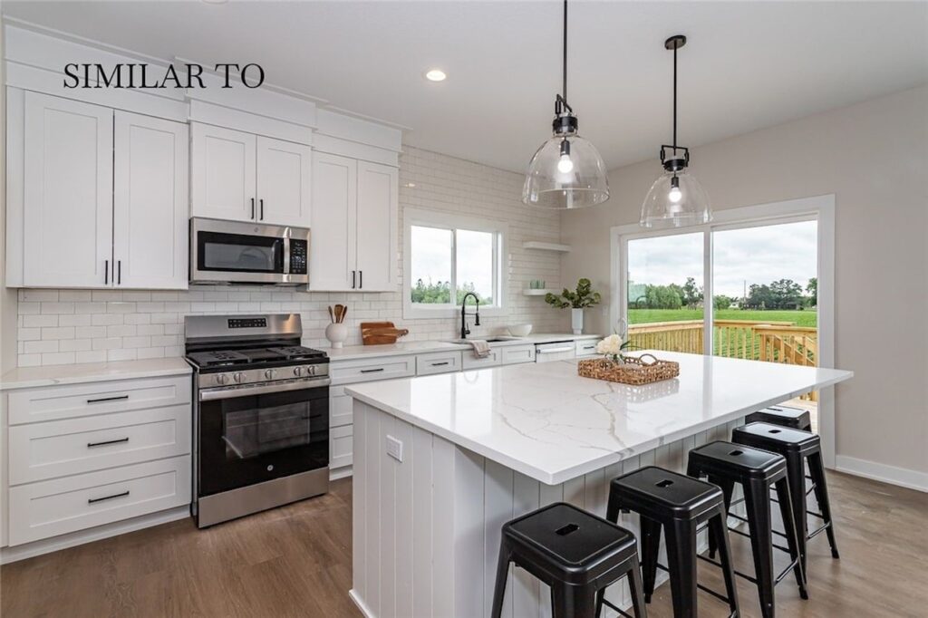 Bright kitchen with white cabinetry and stainless steel appliances, available in new homes for sale at Gladiator Homes, Norwalk, IA.
