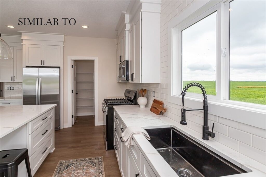 Modern kitchen featuring white cabinets and stainless steel appliances, part of new homes for sale at Gladiator Homes, Norwalk, IA