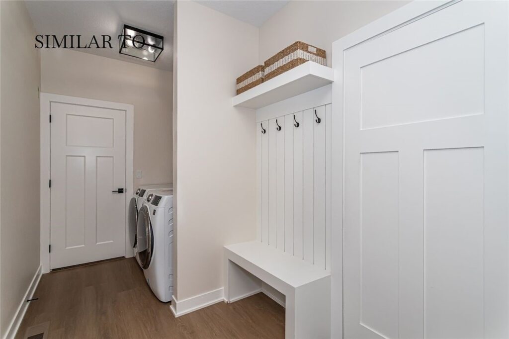 Bright white laundry room featuring a washer and dryer, part of Gladiator Homes for sale at 308 S Valley View Dr, Norwalk, IA.