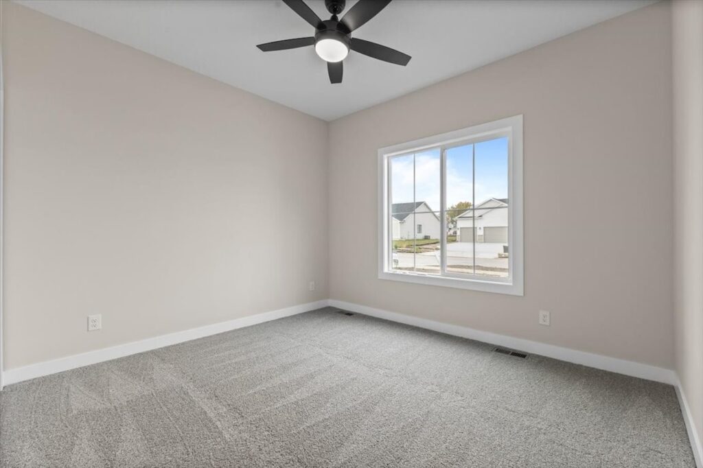 Unfurnished room with a ceiling fan and window, located in the New Gladiator home for sale at 4517 NW 17th St, Ankeny, IA.