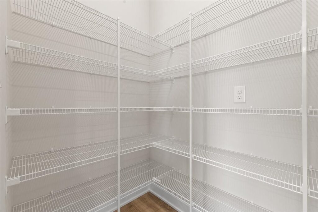 Elegant walk-in closet with shelves and a ladder, emphasizing the storage space in the Gladiator home for sale in Ankeny, IA.