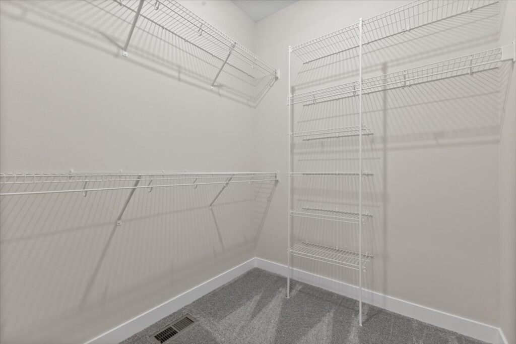 A spacious walk-in closet featuring shelves and a ladder, showcasing storage potential in the Gladiator home for sale.