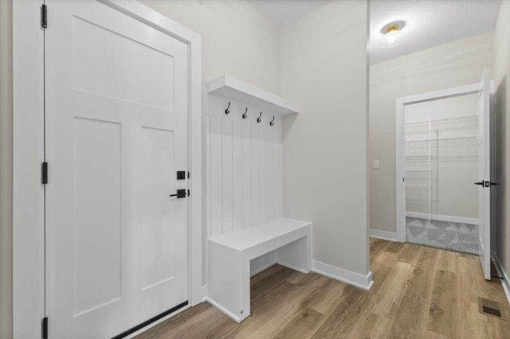 Interior hallway with a white door and bench in the Gladiator home listed for sale at 4517 NW 17th St, Ankeny, IA.