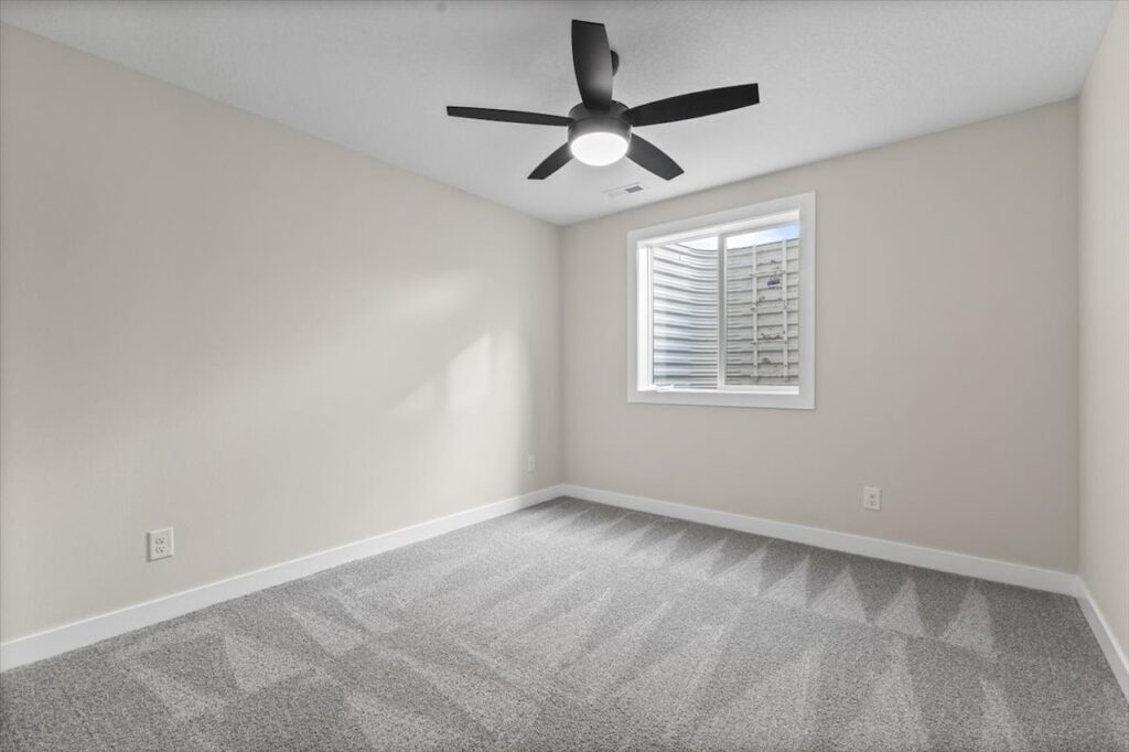 Unfurnished room with a ceiling fan and window, located in the New Gladiator home for sale at 4517 NW 17th St, Ankeny, IA.