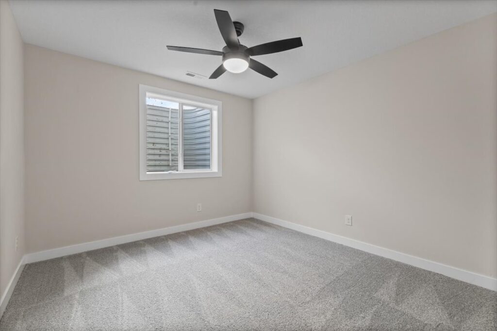 Unfurnished room with a ceiling fan and window, located in the New Gladiator home for sale at 4517 NW 17th St, Ankeny, IA.