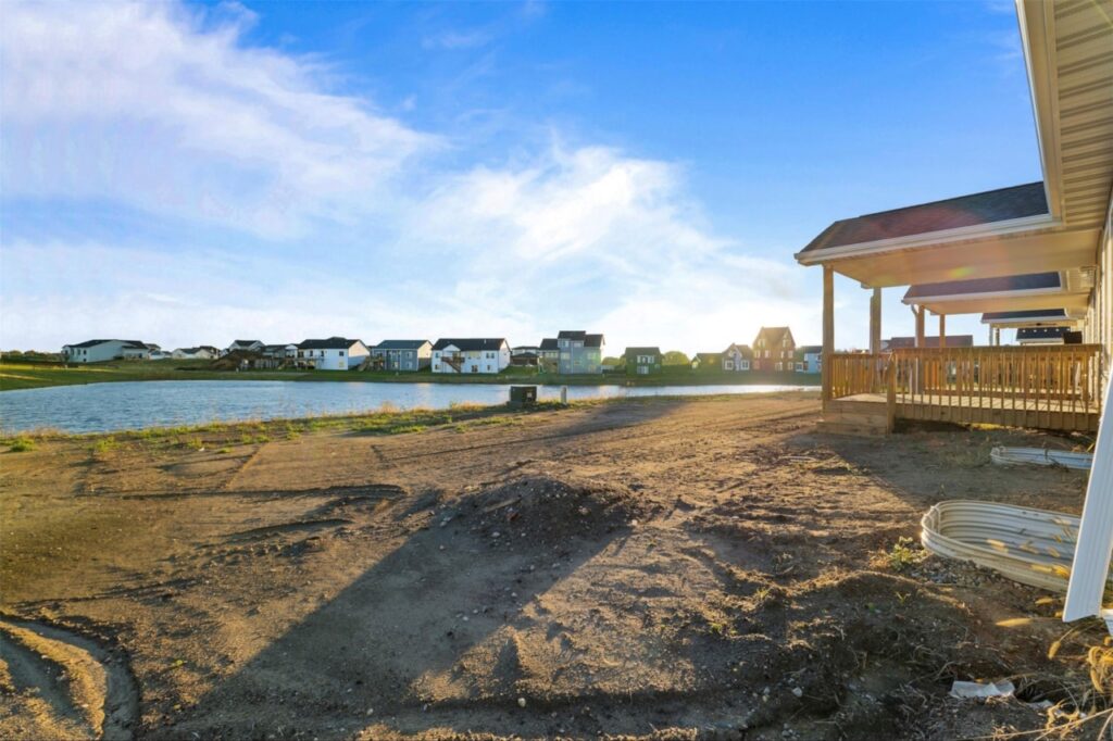 A picturesque house beside a pond in a field, highlighting the New Gladiator home for sale at 4517 NW 17th St, Ankeny, IA.