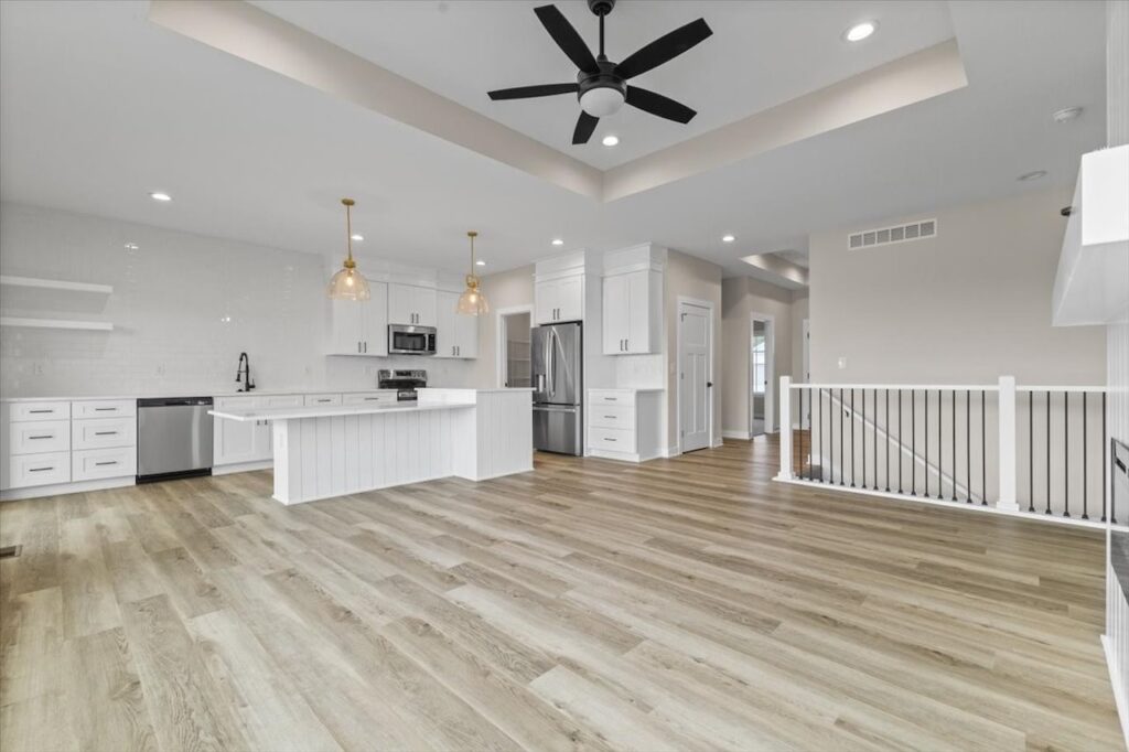 Modern kitchen with white cabinets and wood floors, part of the Gladiator home for sale at 4517 NW 17th St, Ankeny, IA.