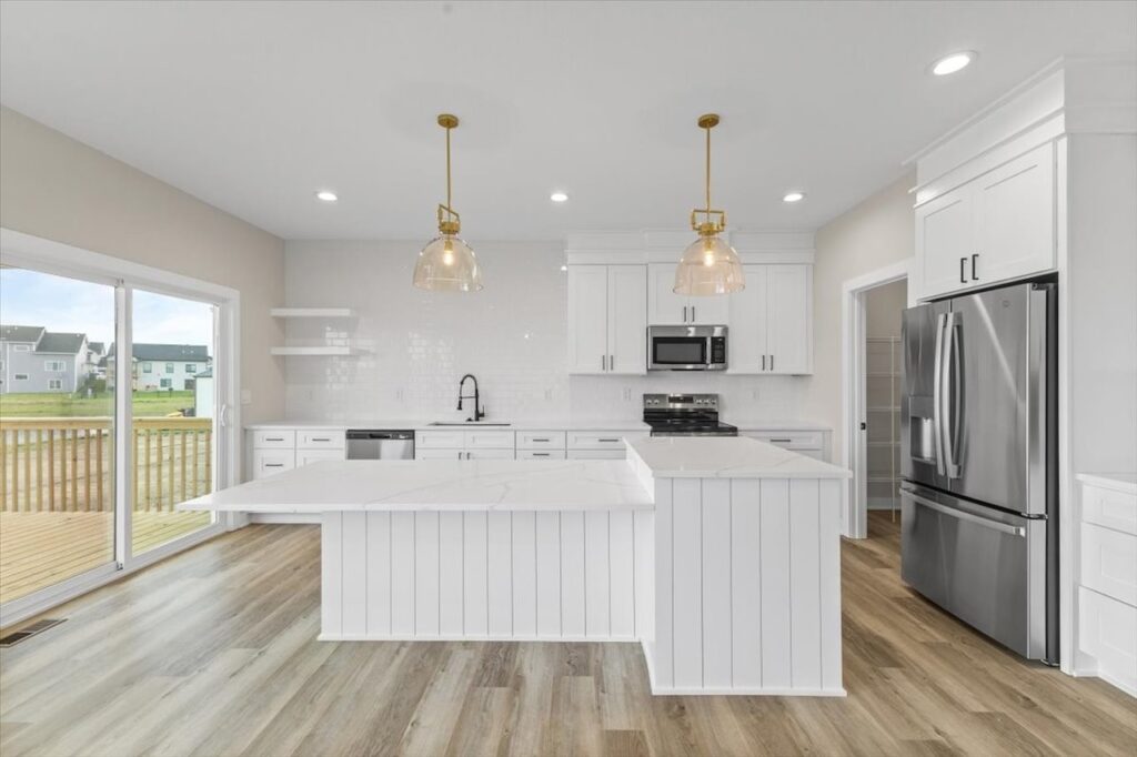 Modern kitchen with white cabinets and wood floors, part of the Gladiator home for sale at 4517 NW 17th St, Ankeny, IA.