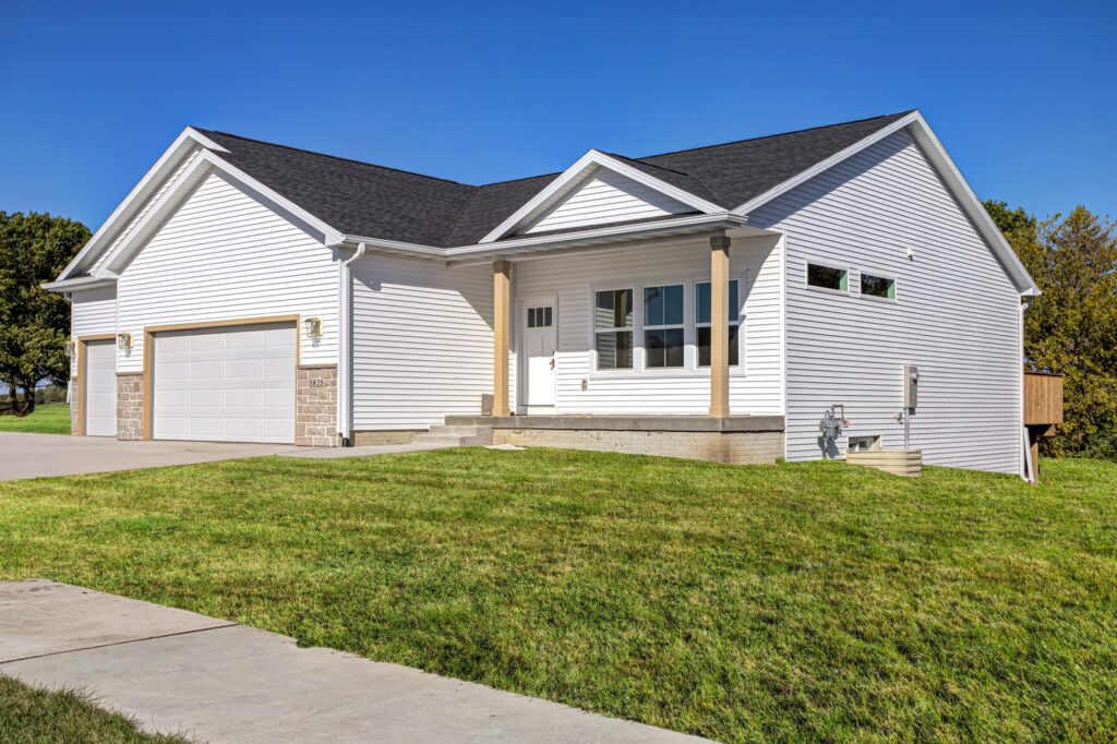 Exterior view of a white house with a garage, listed for sale by Gladiator Homes at 5825 Westfield Dr, Ames, IA.
