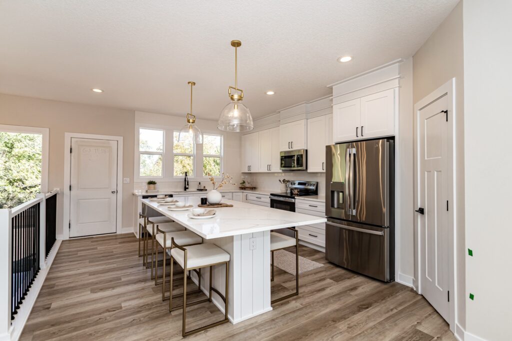 Stylish kitchen with white cabinets and stainless steel appliances, available in Gladiator Homes at 5825 Westfield Dr, Ames, IA