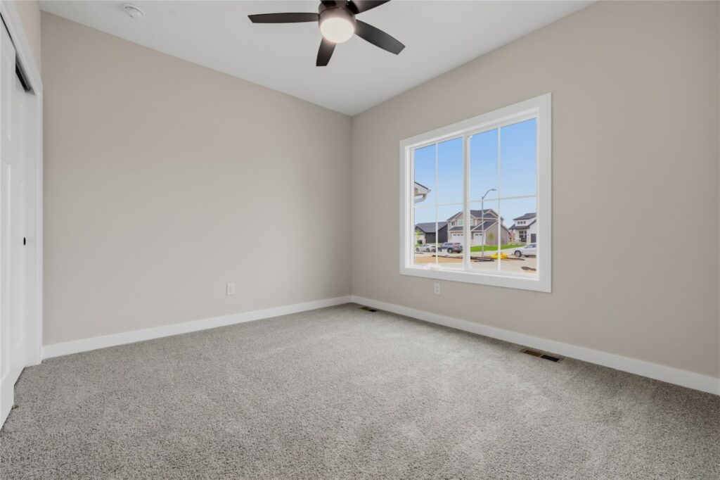 Secondary Bedroom with Ceiling Fan and Neighborhood Views – New Home in Waukee, IA | Gladiator Homes