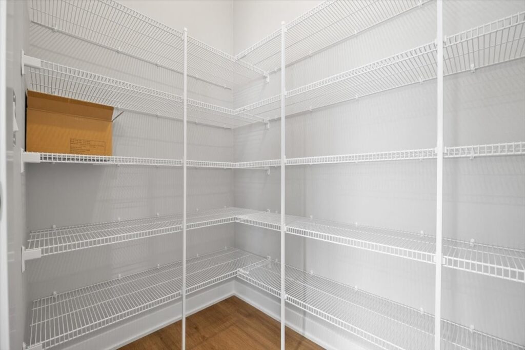 Interior of a pantry featuring shelves and a box, highlighting storage space in the home available at 321 11th St NW, Bondurant, IA.