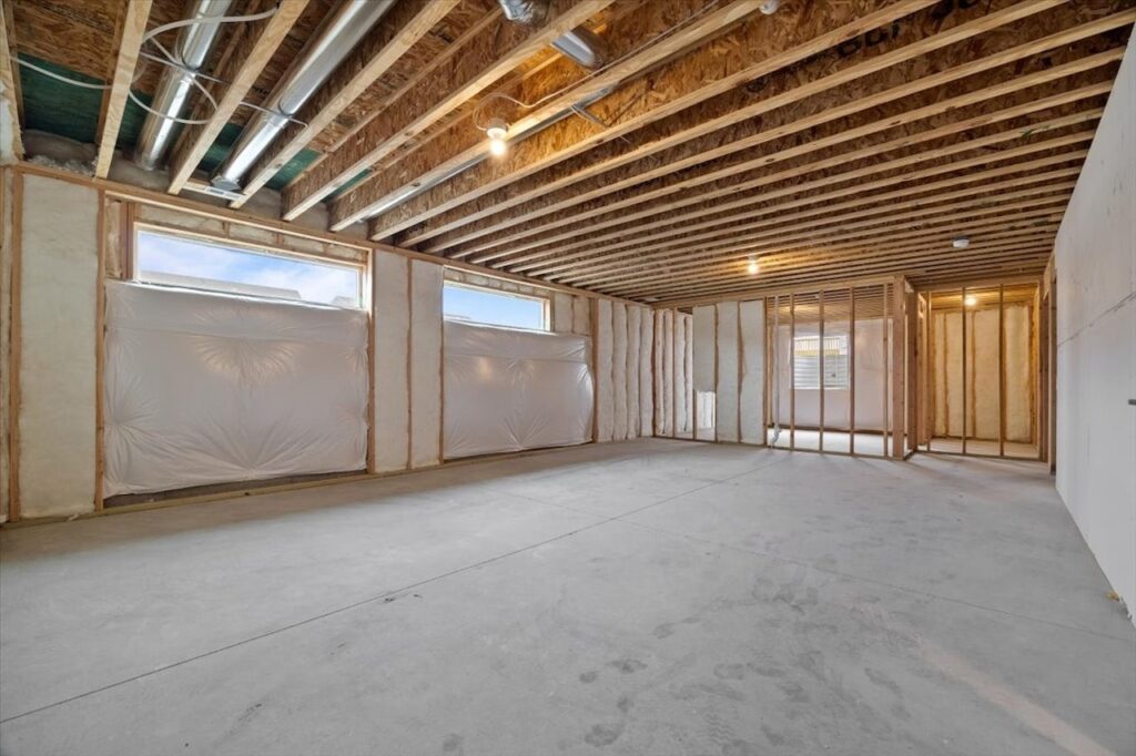 Empty room with drywall-covered walls and ceiling, part of available homes for sale at 321 11th St NW, Bondurant, IA.