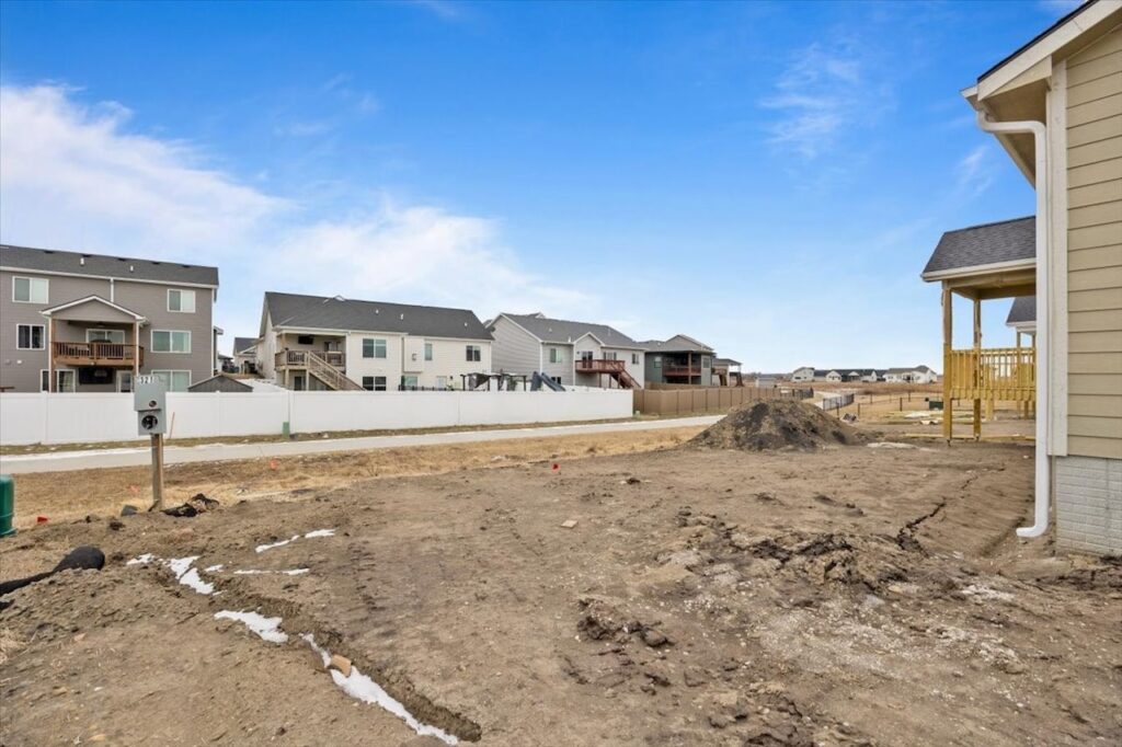 A new house being built on a dirt lot, featuring a sign for available homes at 321 11th St NW, Bondurant, IA.