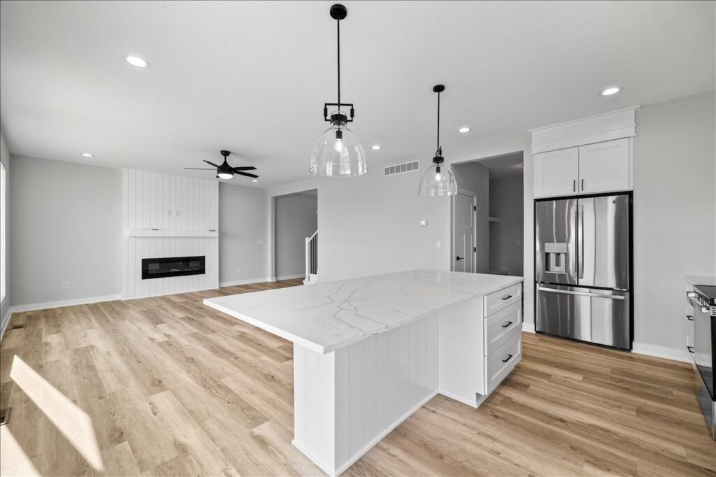 Kitchen featuring white cabinets and hardwood floors, part of the home for sale at 675 NW Rosemont Dr, Waukee, IA.