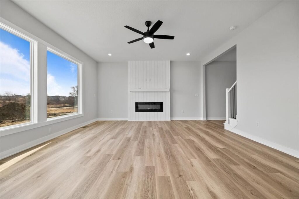 Bright open kitchen with hardwood flooring and a ceiling fan, available in the home for sale at 675 NW Rosemont Dr, Waukee, IA.