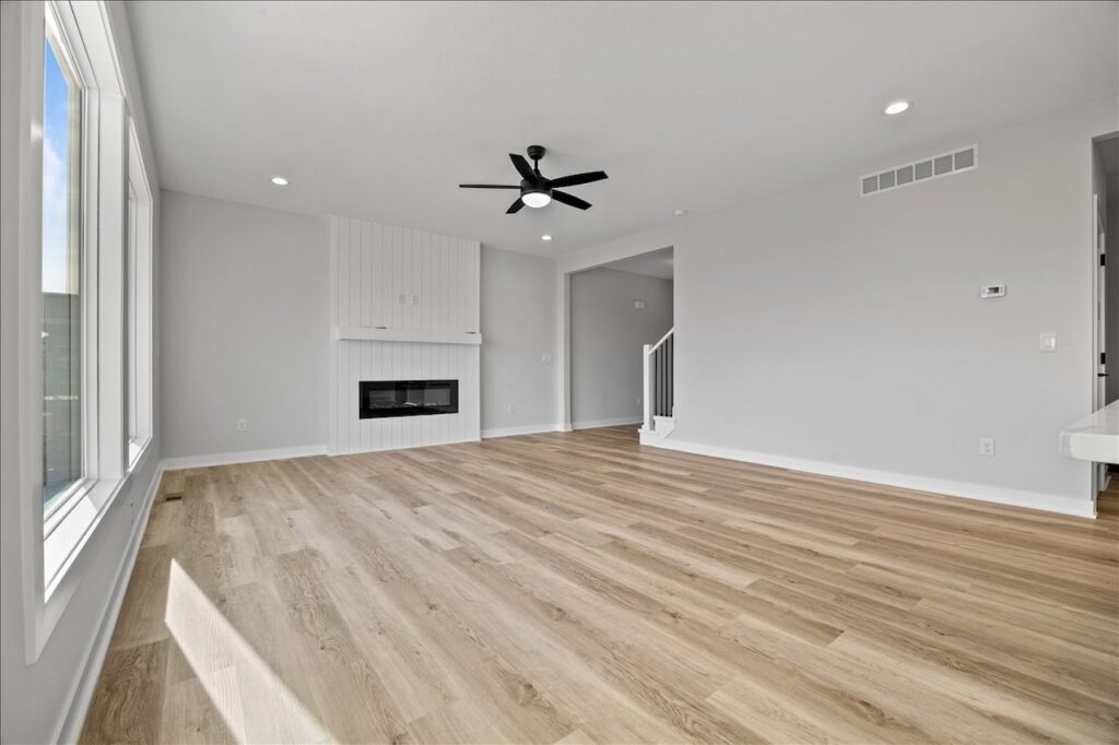 Bright open kitchen with hardwood flooring and a ceiling fan, available in the home for sale at 675 NW Rosemont Dr, Waukee, IA.