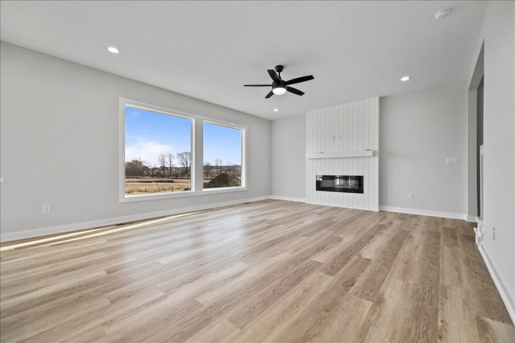 Spacious kitchen showcasing hardwood floors and a ceiling fan, part of the home for sale at 675 NW Rosemont Dr, Waukee, IA.