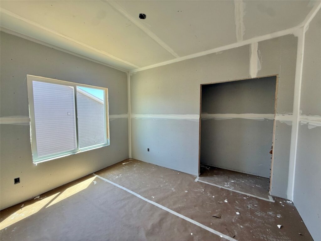 Under-construction home featuring a garage, with a bright blue sky in the background, at 722 W Wright Rd, Norwalk, IA.